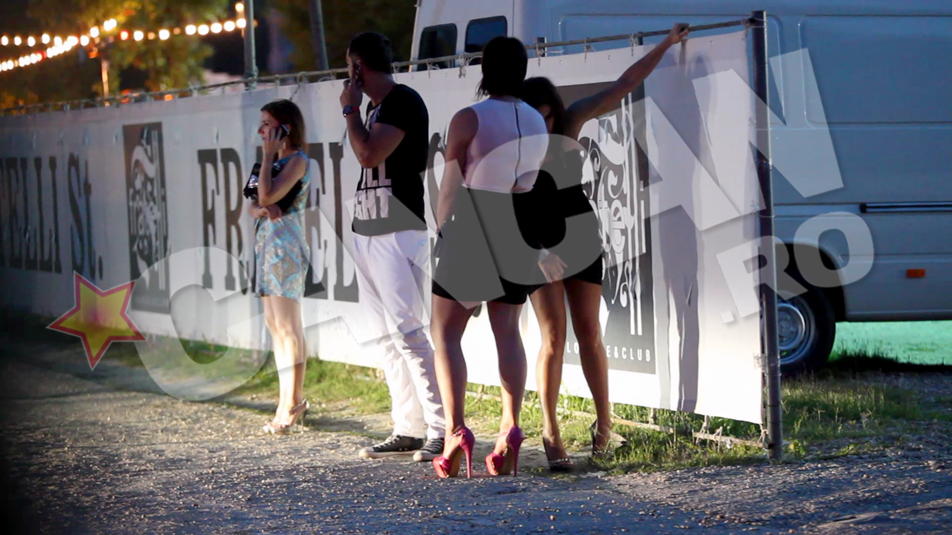 Patricia se tine de un gard, in vreme ce Oana face eforturi disperate sa ramane in picioare, pe tocurile imense. Novanc suna in disperare dupa un taxi