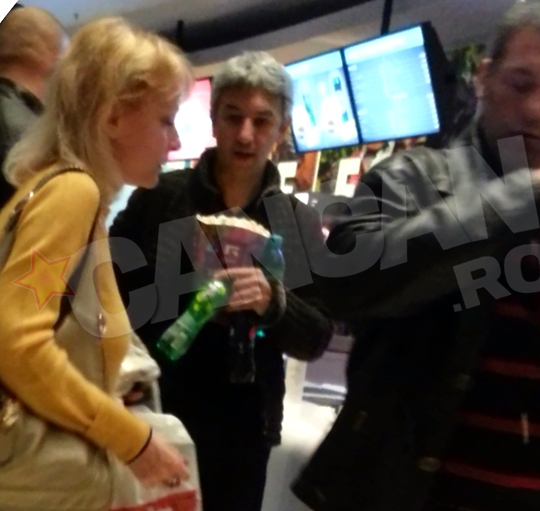 Domnul Dan si-a umplut bratele cu suc si popcorn