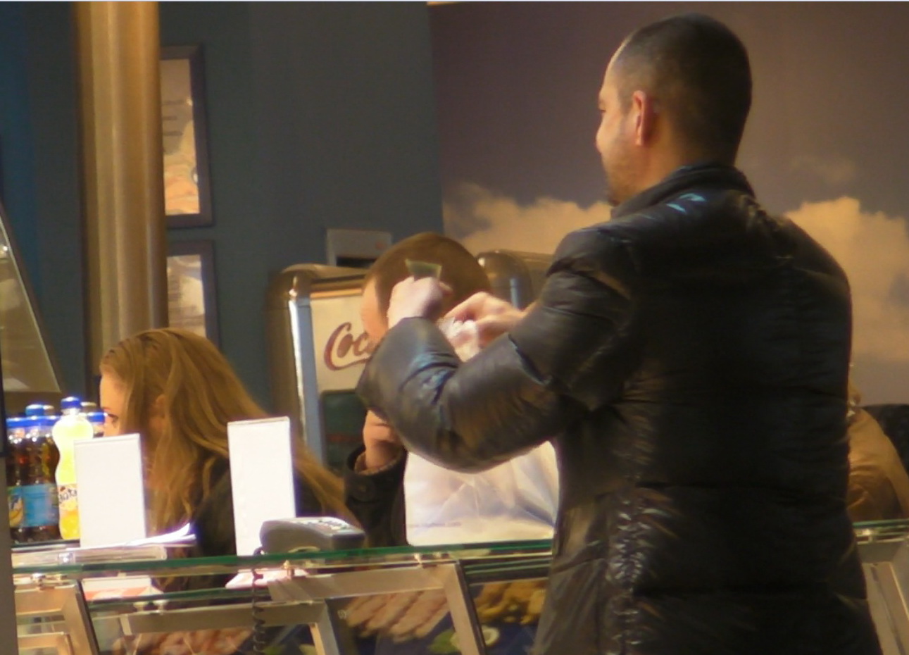 Inainte sa plece, prezentatorul tv ii multumeste vanzatoarei, apoi ii zambeste