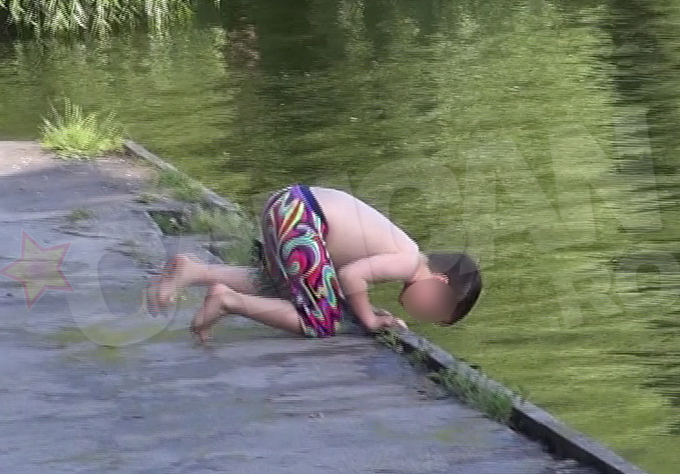 Fara sa isi dea seama la ce risc se expune, baiatul s-a apropiat de malul lacului si s-a aplecat peste marginea de beton