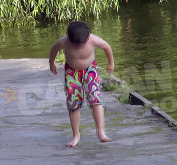 Fericit ca a scapat de caldura, baiatul a inceput sa danseze pe malul lacului