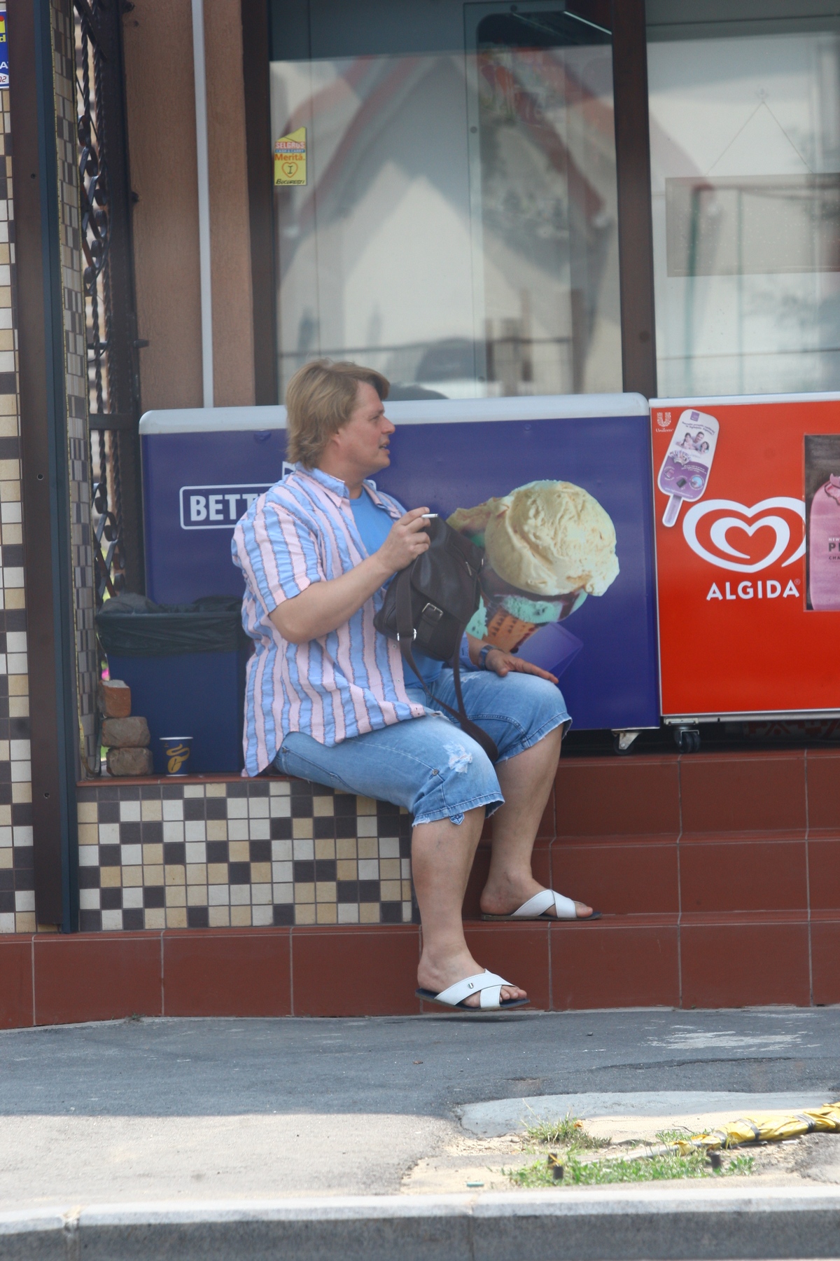 Cand s-a plictisit de cumapraturi indragistul bucatar a iesit pe treptele magazinului ca sa fumeze