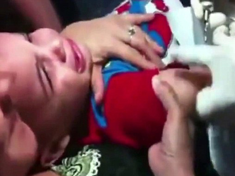 Momente teribile! O mamă îşi ţine copilaşul de trei ani, în timp ce acesta se zbate şi plânge, pentru a-i face un tatuaj!