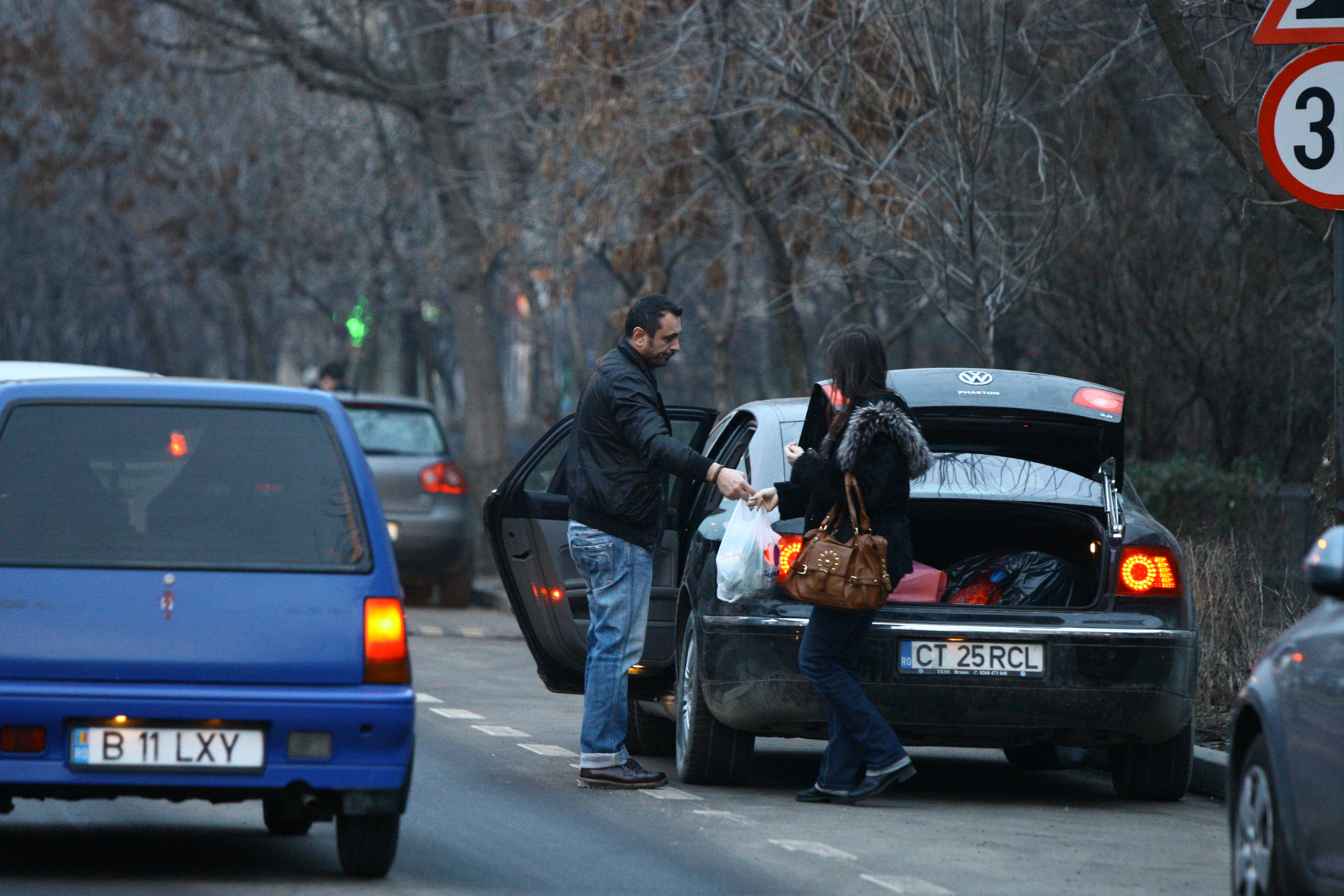 Barbatul ii intinde sotiei sale punga pentru a duce in casa
