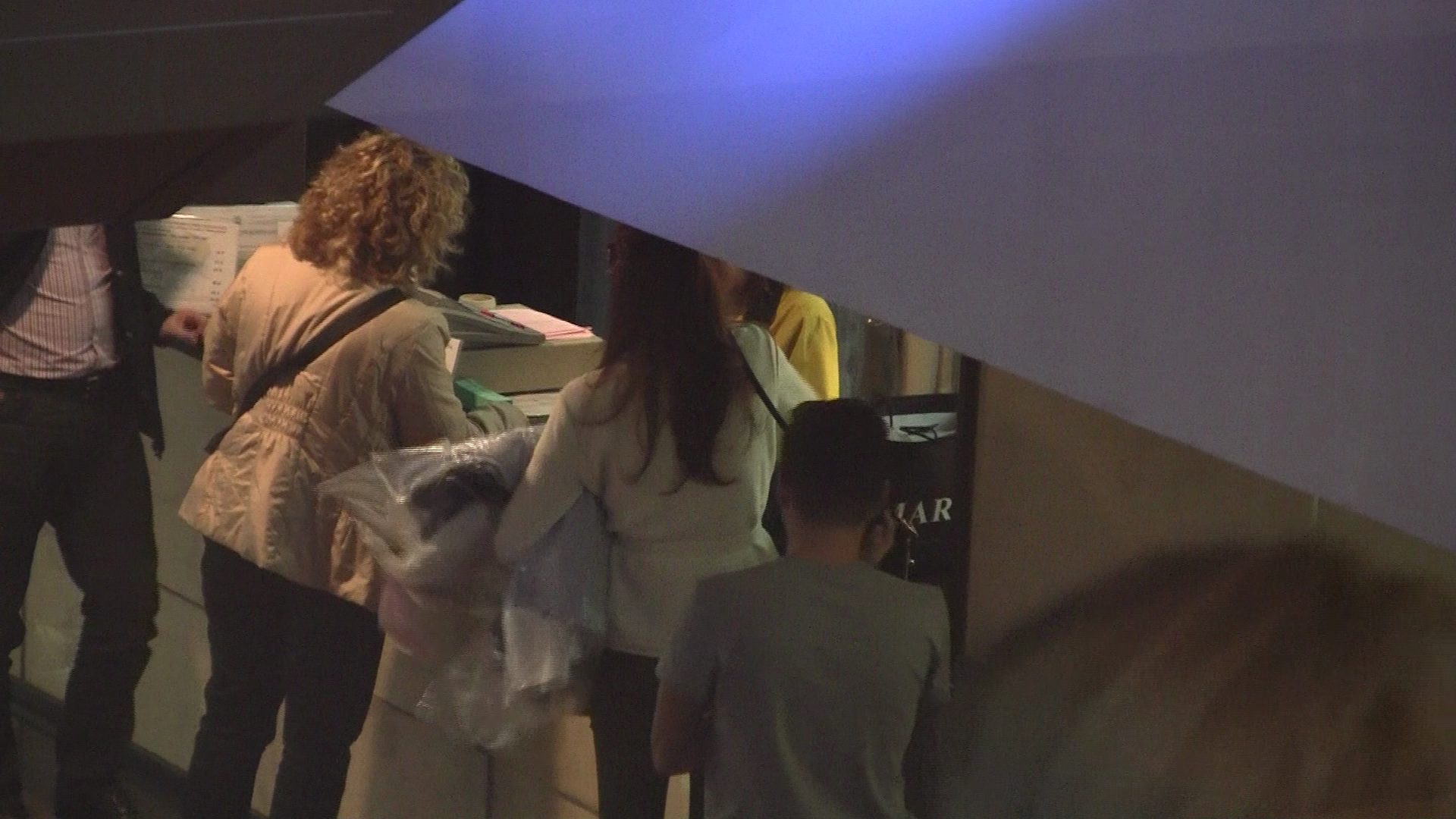 Cu bratul plin de camasi, se pregateste sa plateasca