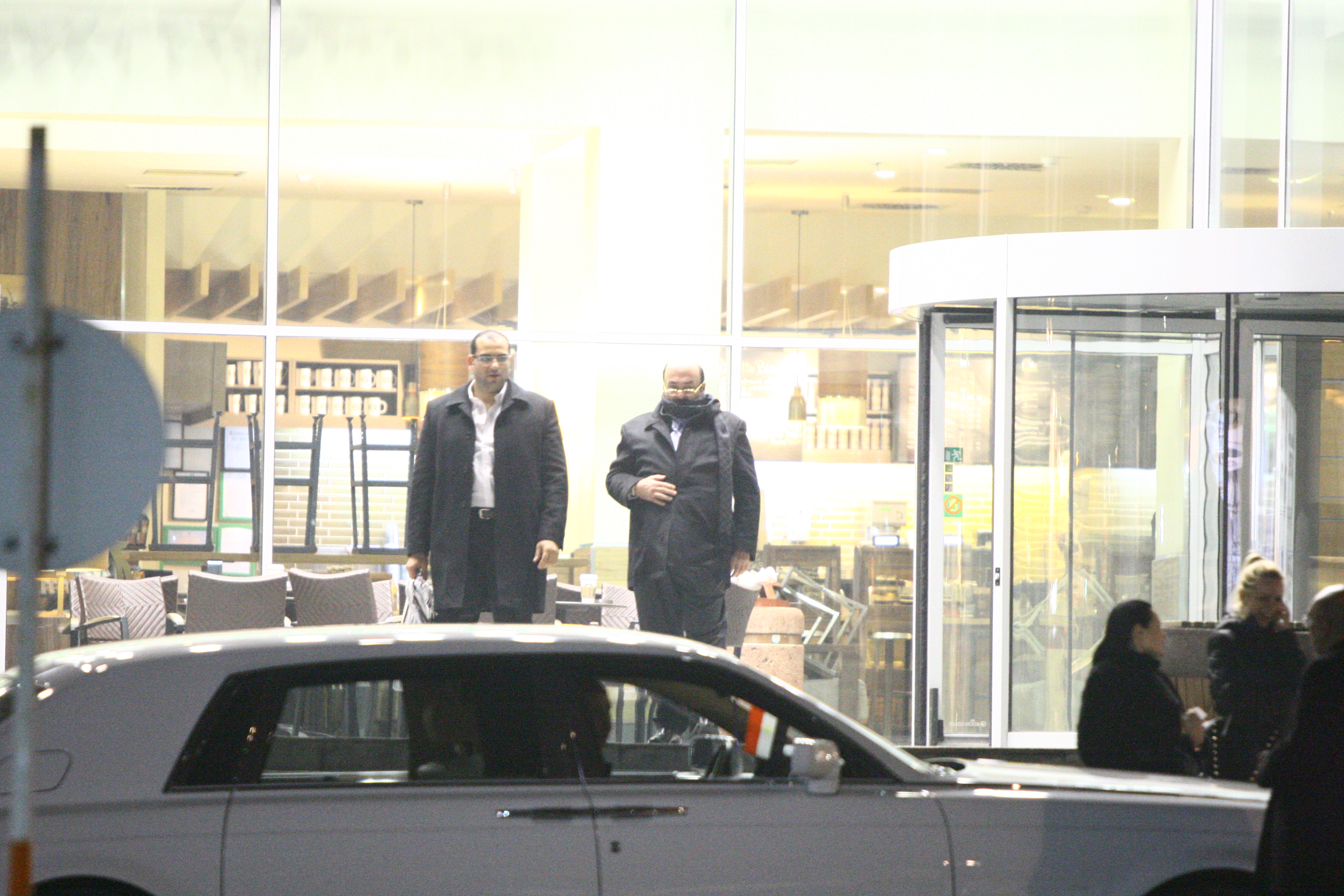 Hassan iese din mall in compania unuia dintre bodyguarzii sai