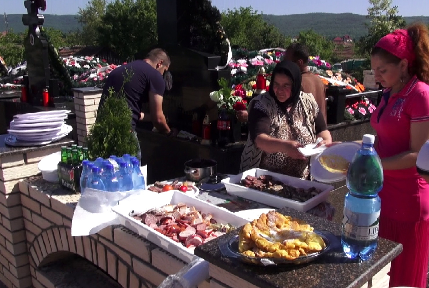 Femeile aranjeaza de zor platourile cu mezeluri si fripturi