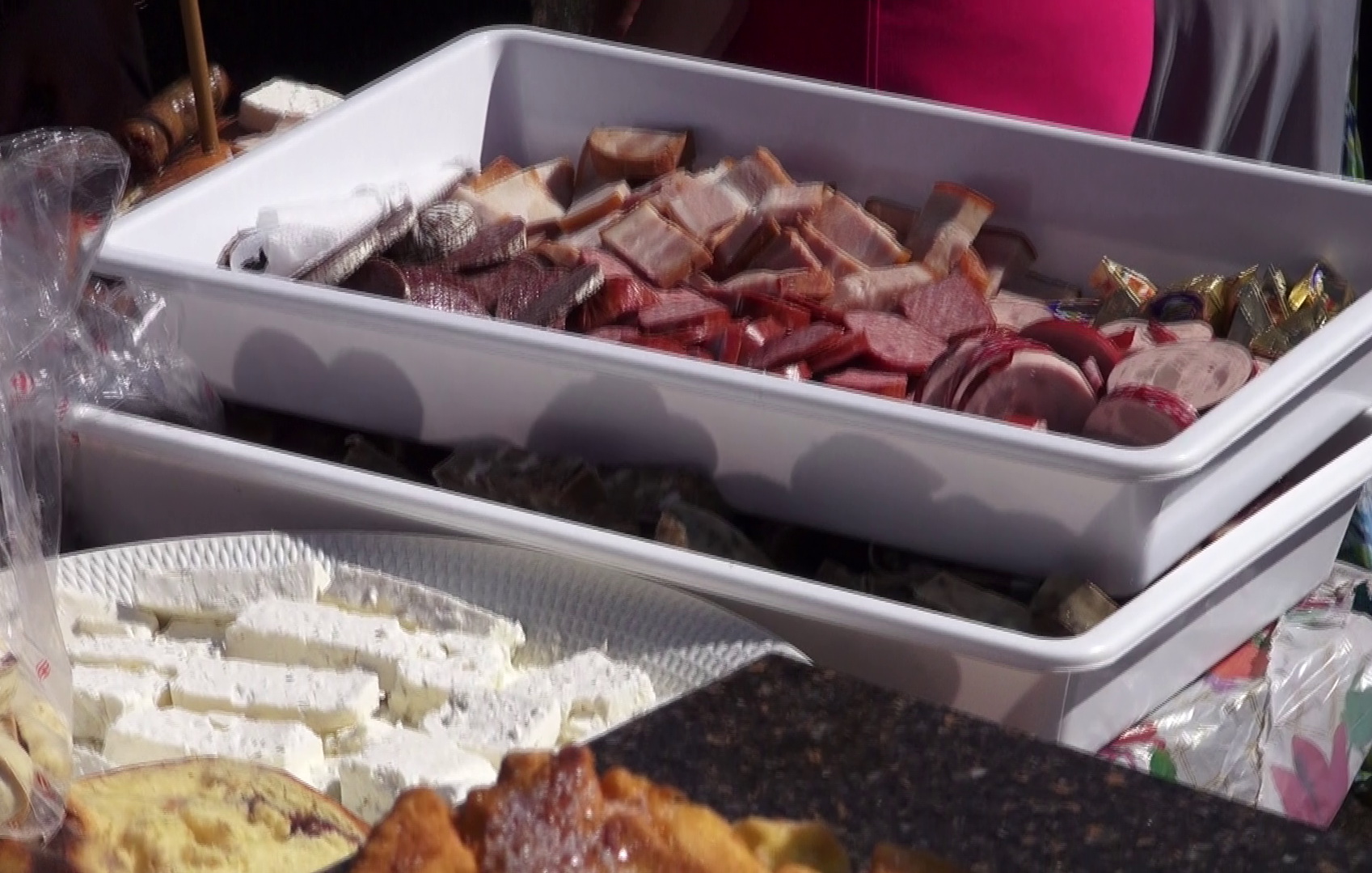 Ligheanele pline cu mezeluri feliate si platourile cu branzeturi, gata sa fie date de pomana