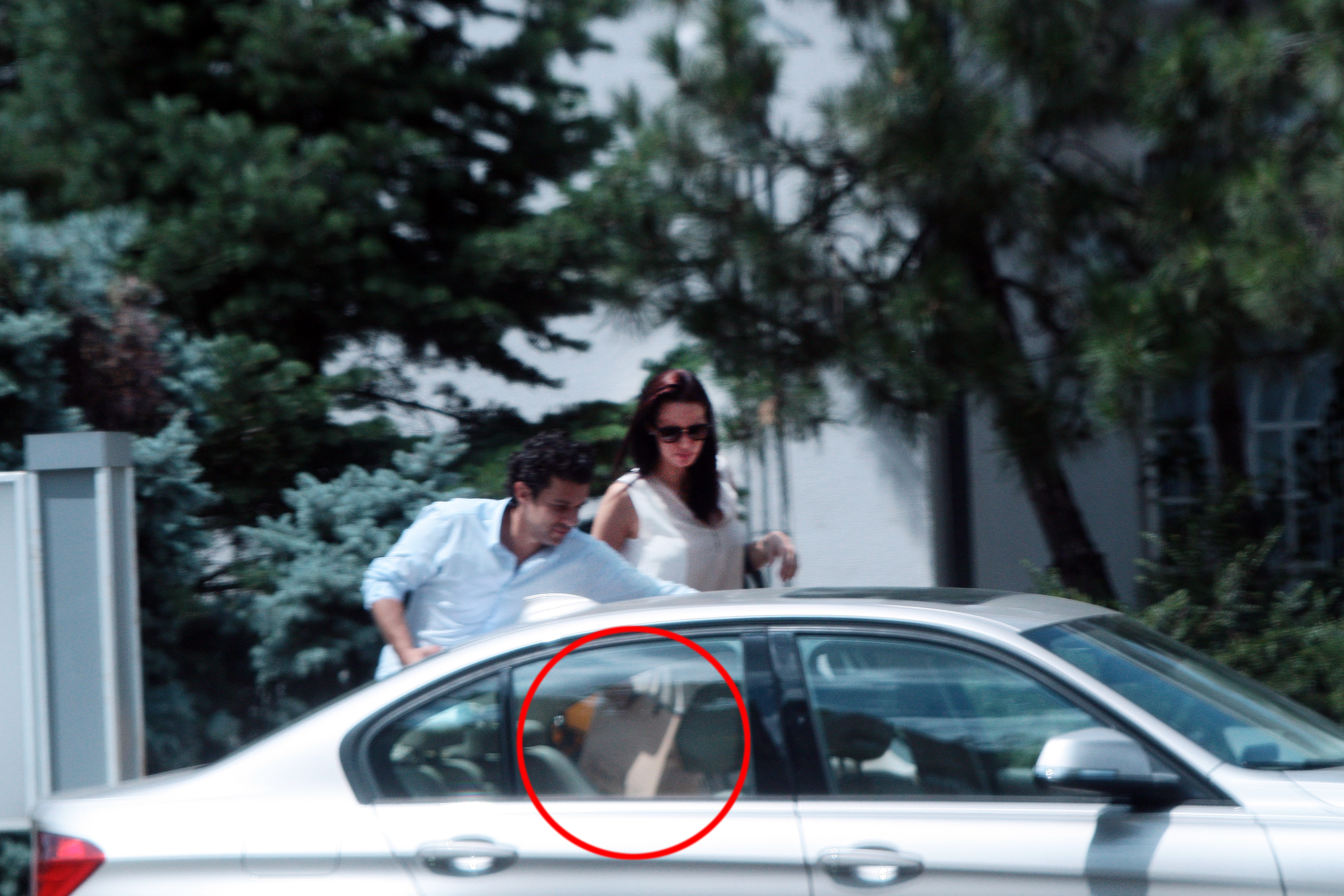 Barbatul care o insoteste, aseaza cu grija cutia cu bunatati pe bancheta din spate a masinii