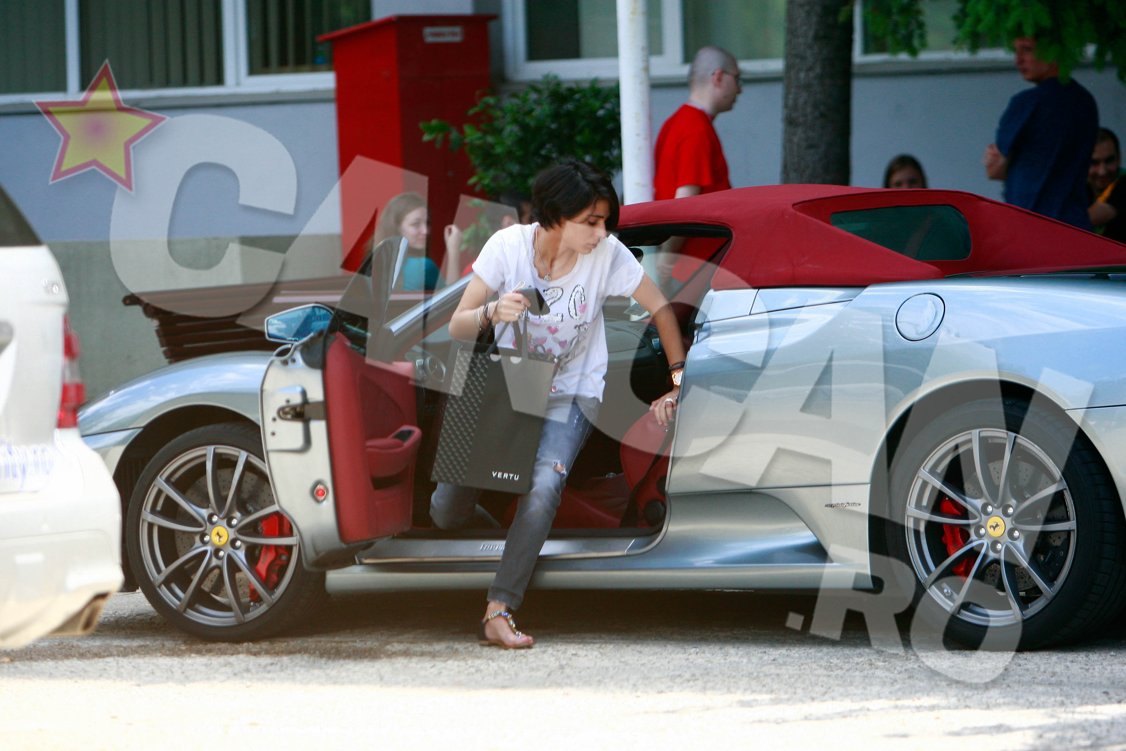 De mana i s-a lipit o geanta Hermes Birkin - pret de catalog 6.500 de euro. Sub soare mai sticlesc un ceas din aur roz de 22 de carate, 30.000 de euro, doua inele cu briliante care valoreaza tot atat, o bratara cu nestemate de 15.000 de euro si un telefon de 30.000 de euro