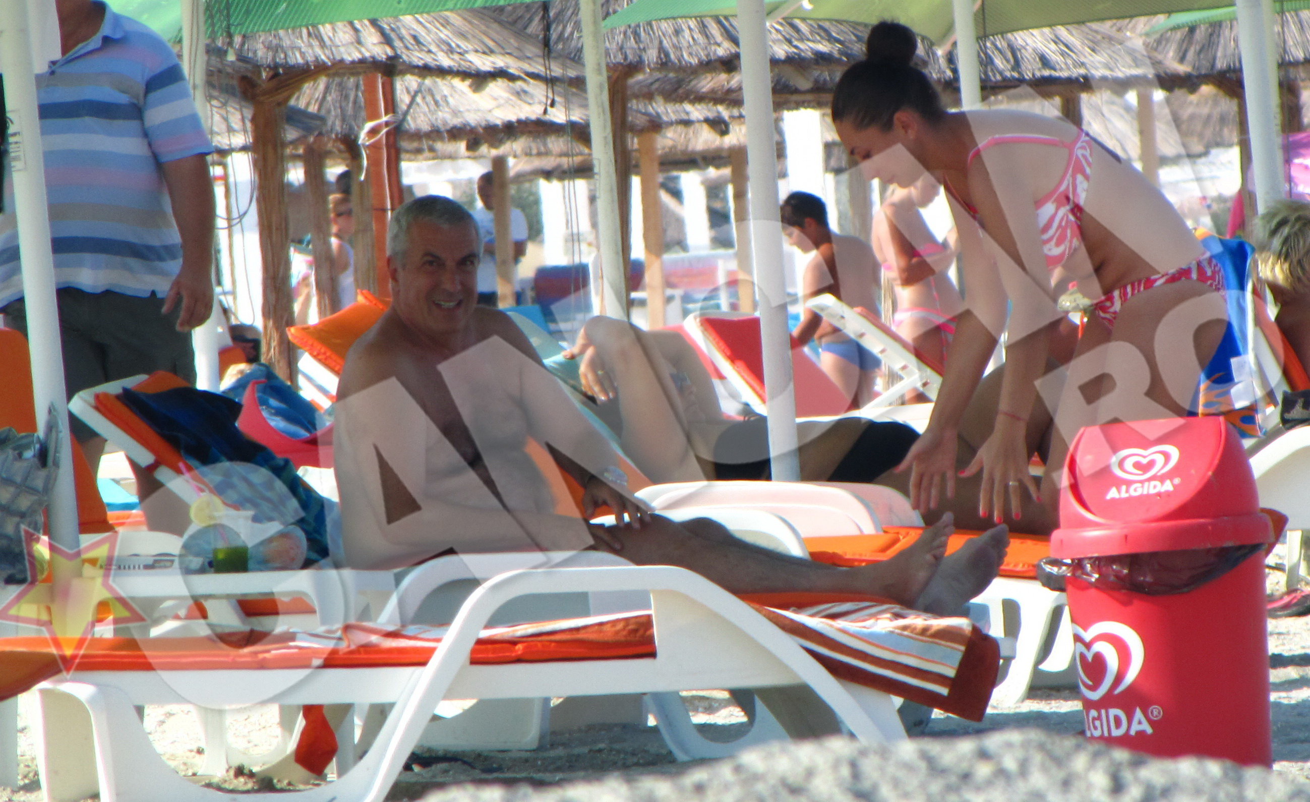 Ca sa treaca timpul mai repede, cei doi stau pe sezlong si...consuma: el- o piersica, ea - un cocktail