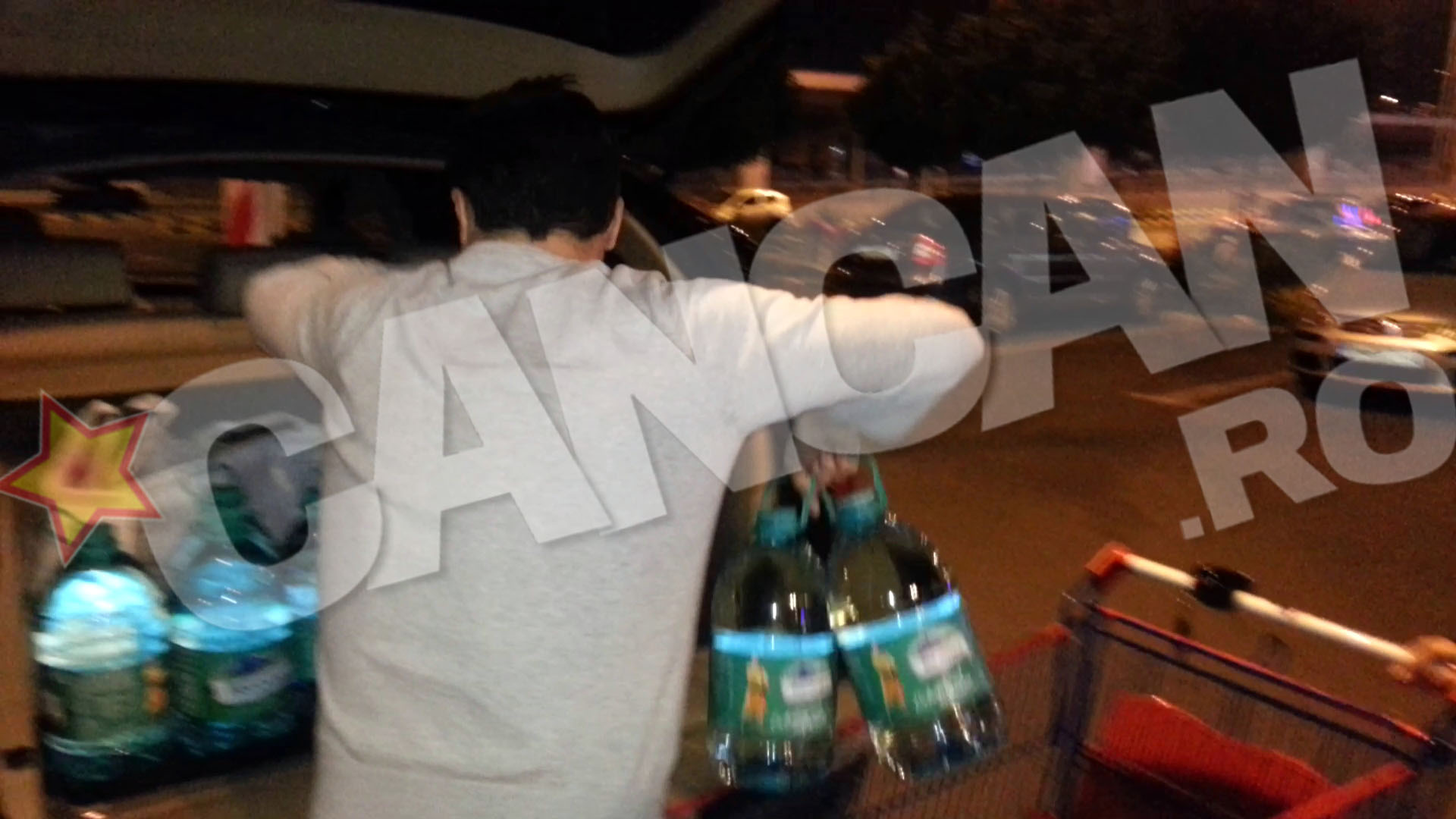 Cei doi au umplut cosul de cumparaturi cu multe bidoane de apa