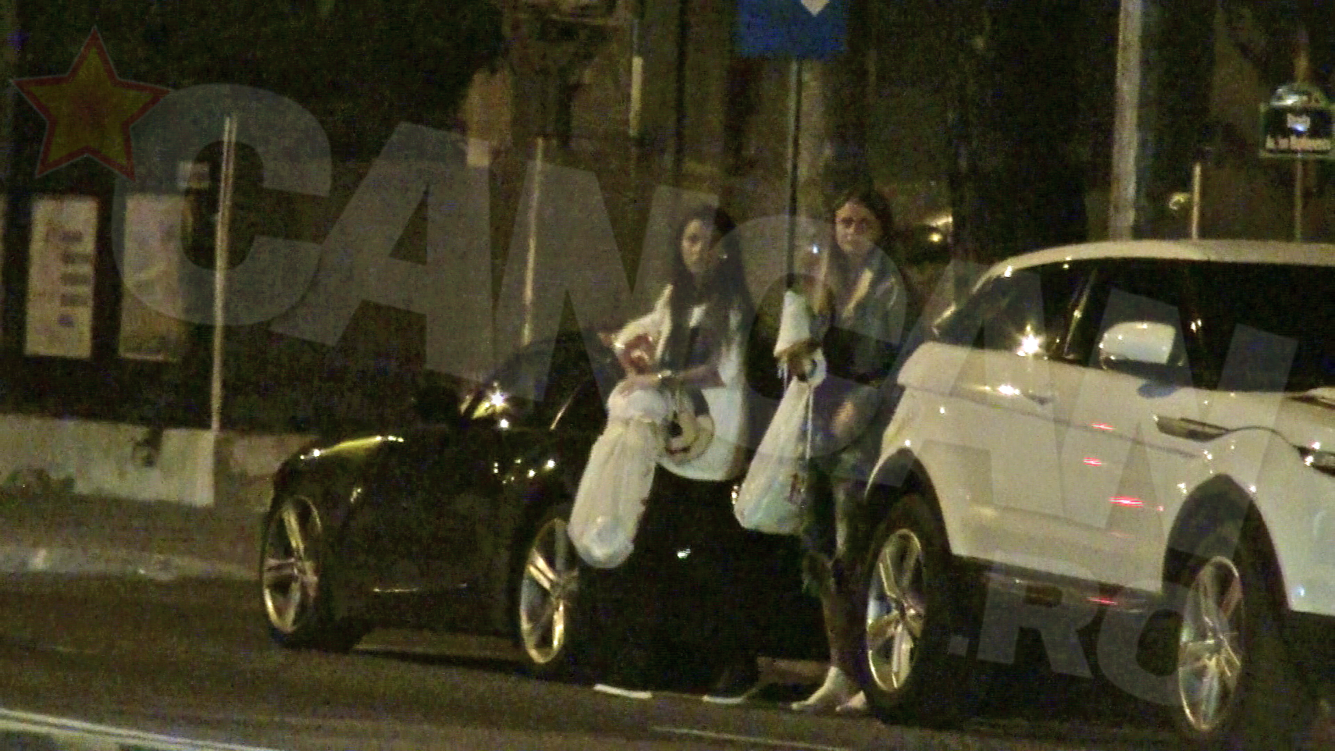 Prietena ei o ajuta sa puna in portbajag cumparaturile facute in plina noapte