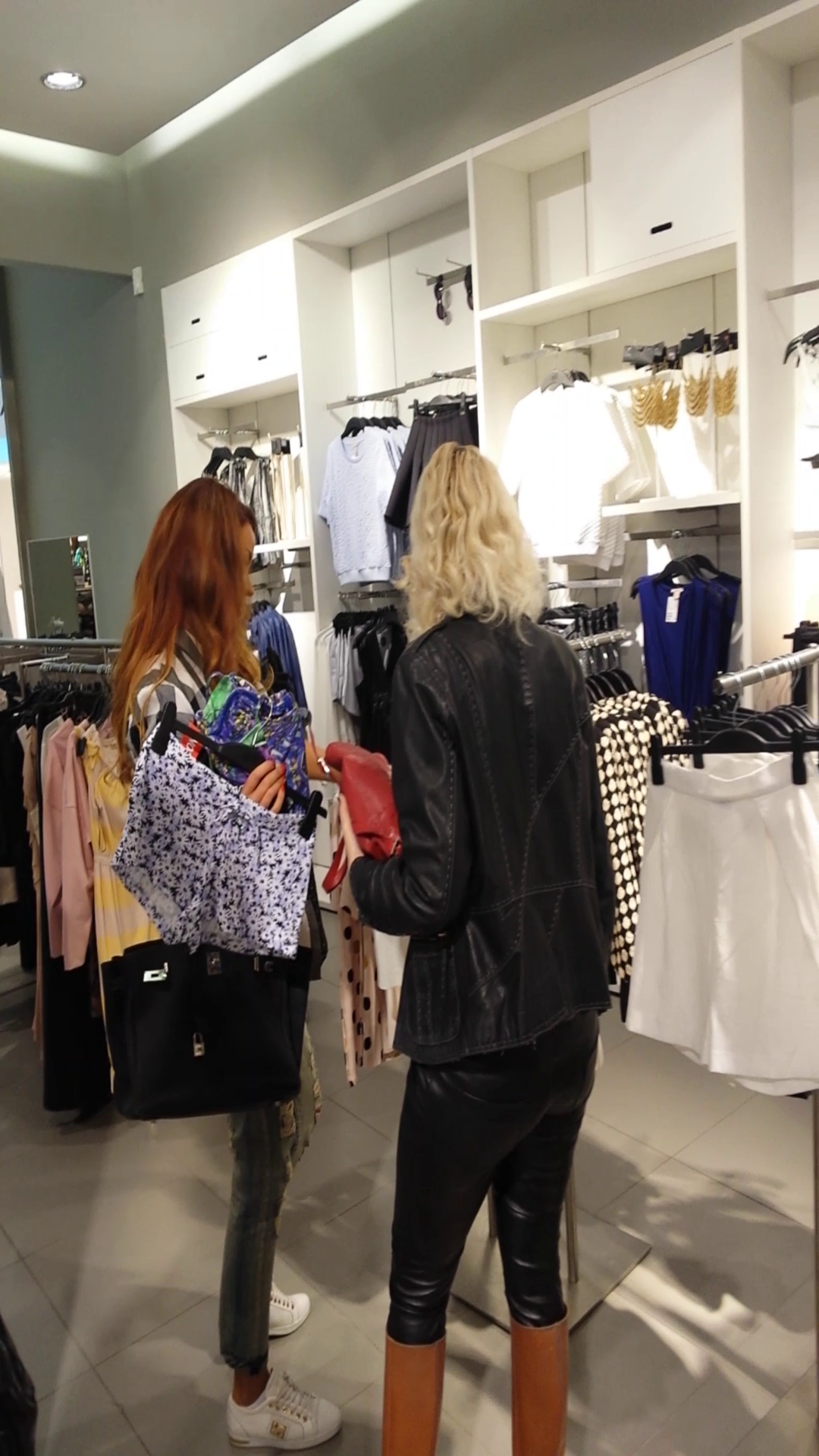 Bianca a iesit dintr-un magazin cu bratul plin de costume de baie si obiecte de lenjerie intima