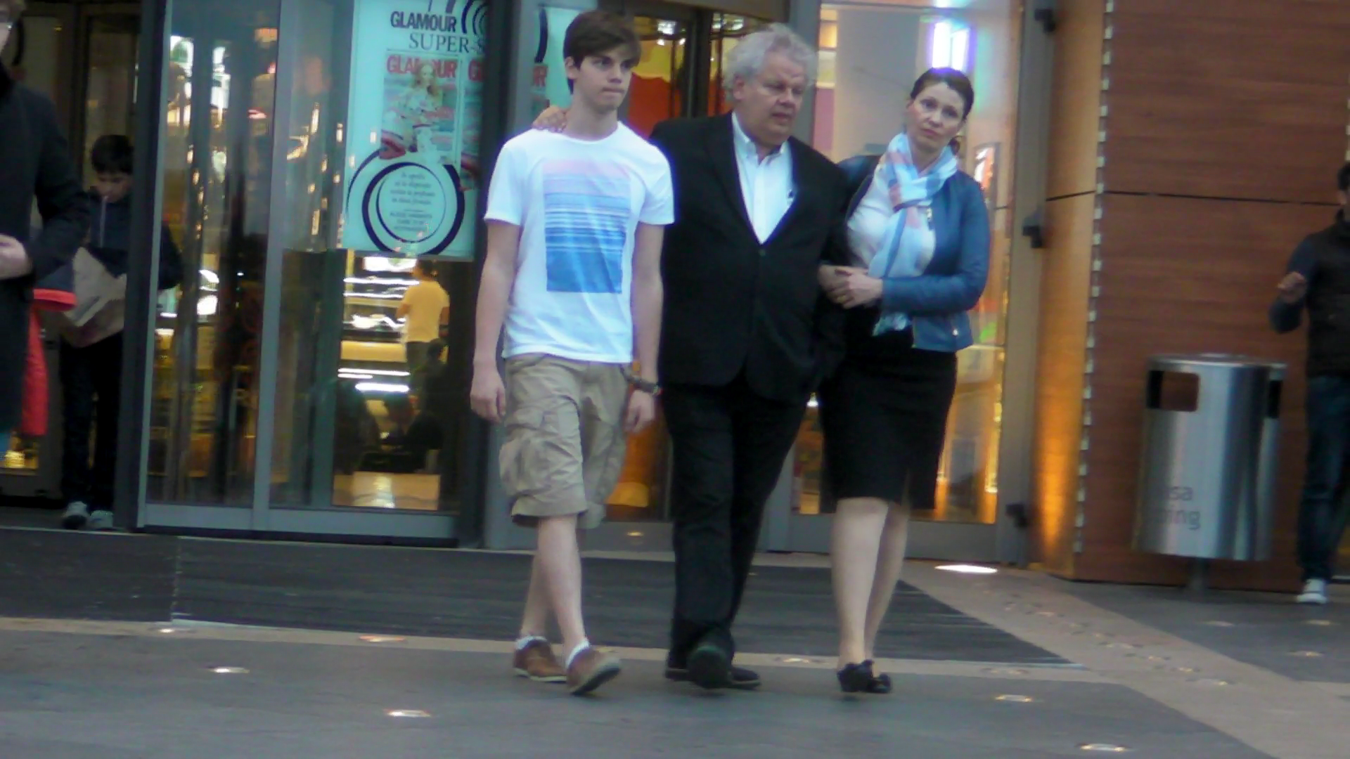 Milionarul a iesit din mall flancat de unul dintre cei doi fii ai sai si de sotie