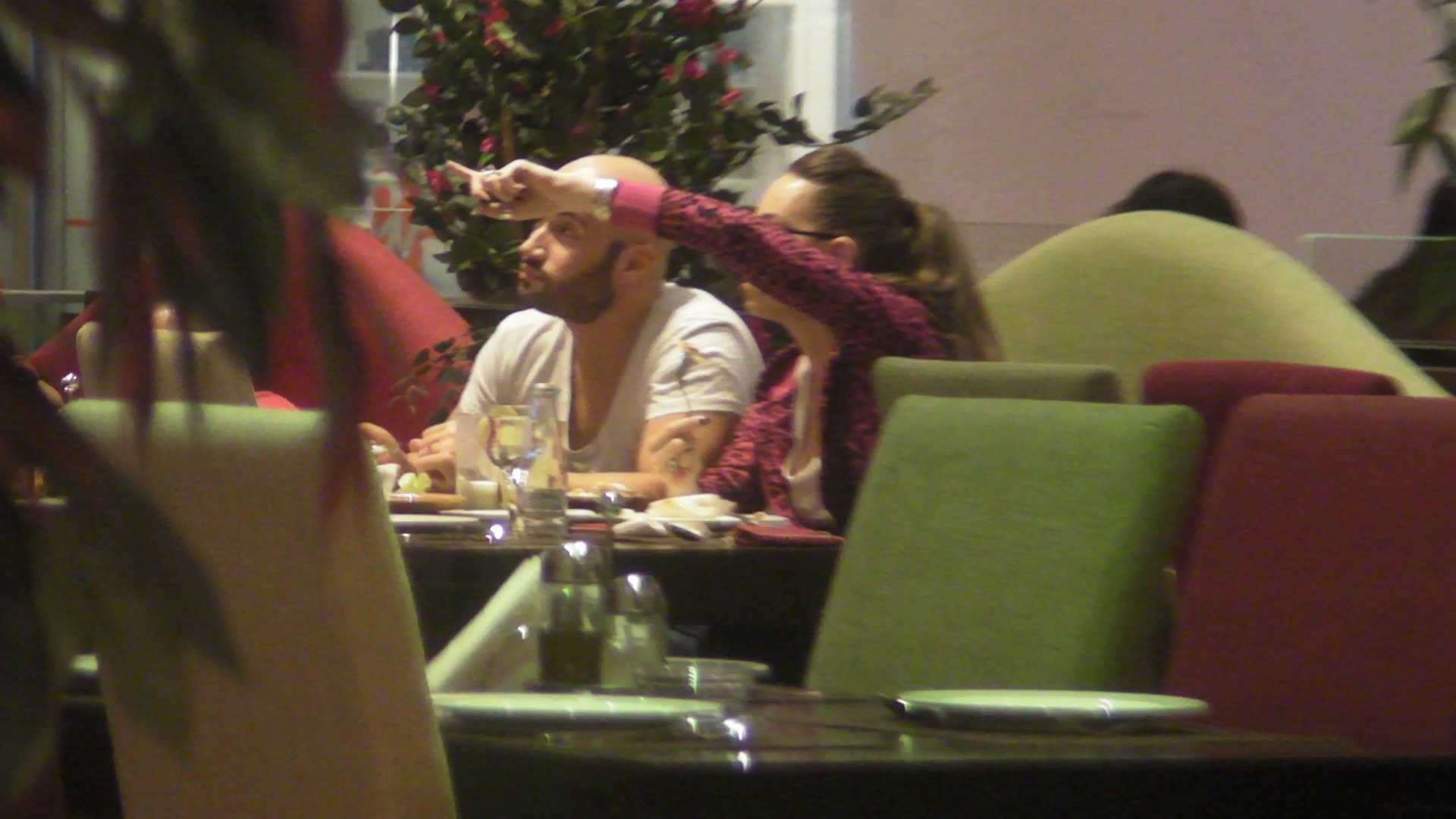 Fata ii atrage atentia asupra unei scene de la televizor, aratand cu degetul