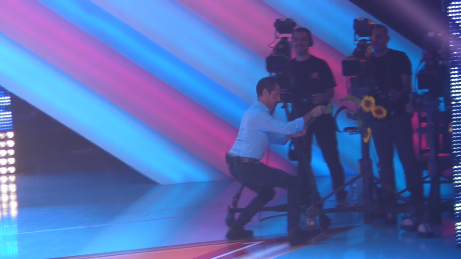 Banica se joaca cu floare artificiala prin fata camerelor de filmat