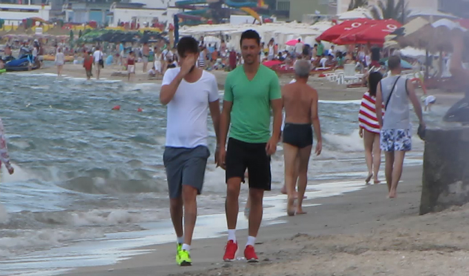 Cei doi renunta la alergare si merg usor pe malul marii