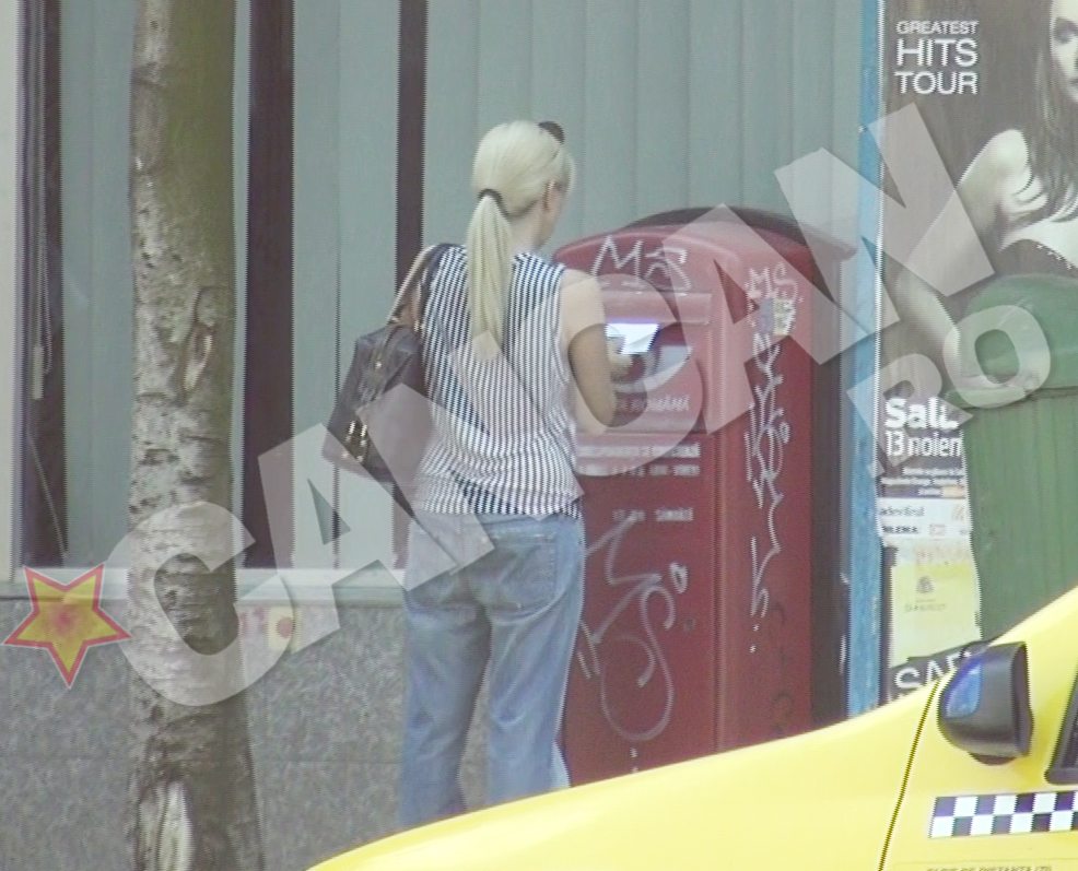 Femeia pune scrisoarea in cutia postala