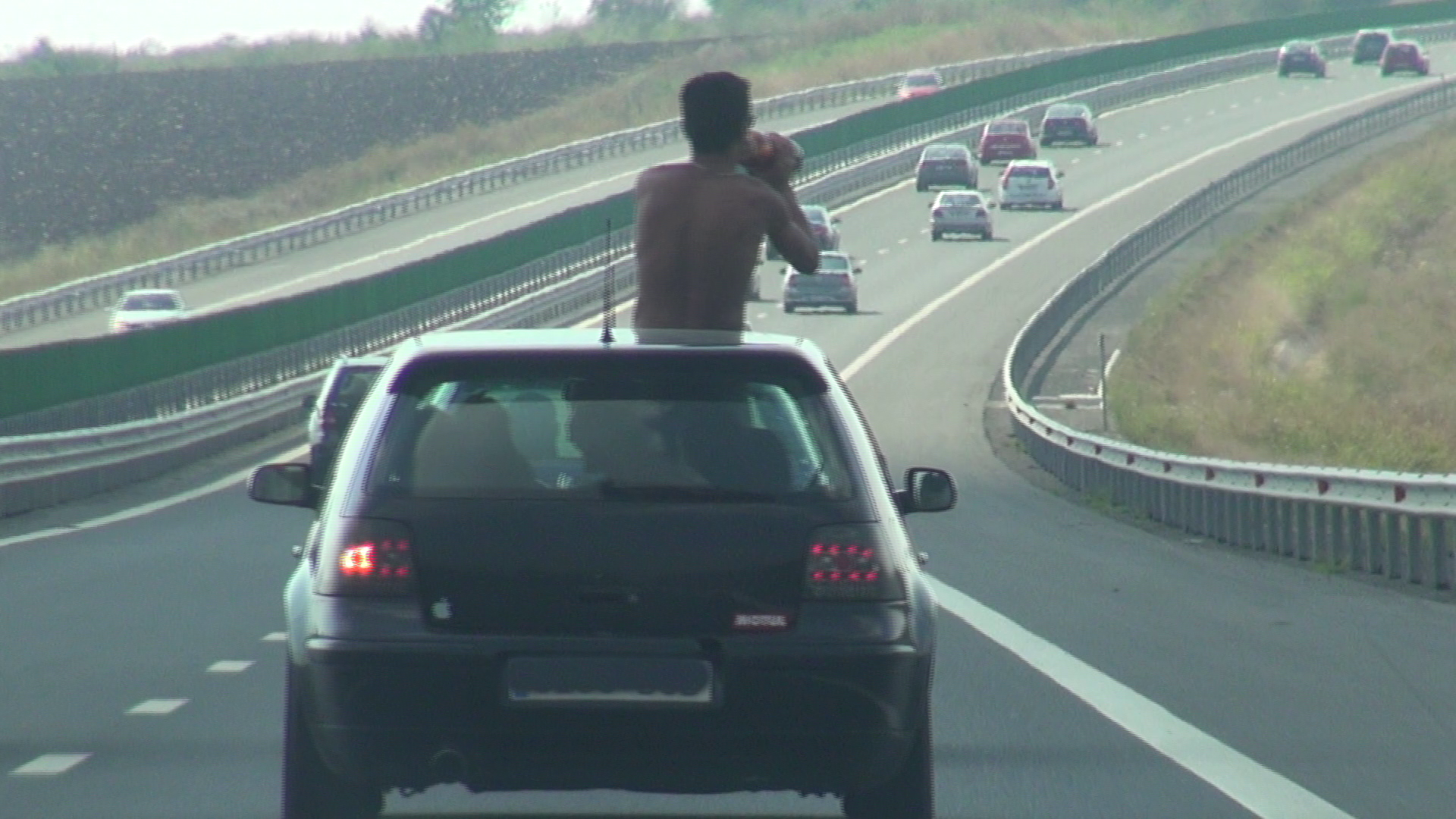 Un tanar care a iesit pe trapa masinii s-a apucat sa traga cu sete dintr-un pet de bere la doi litri