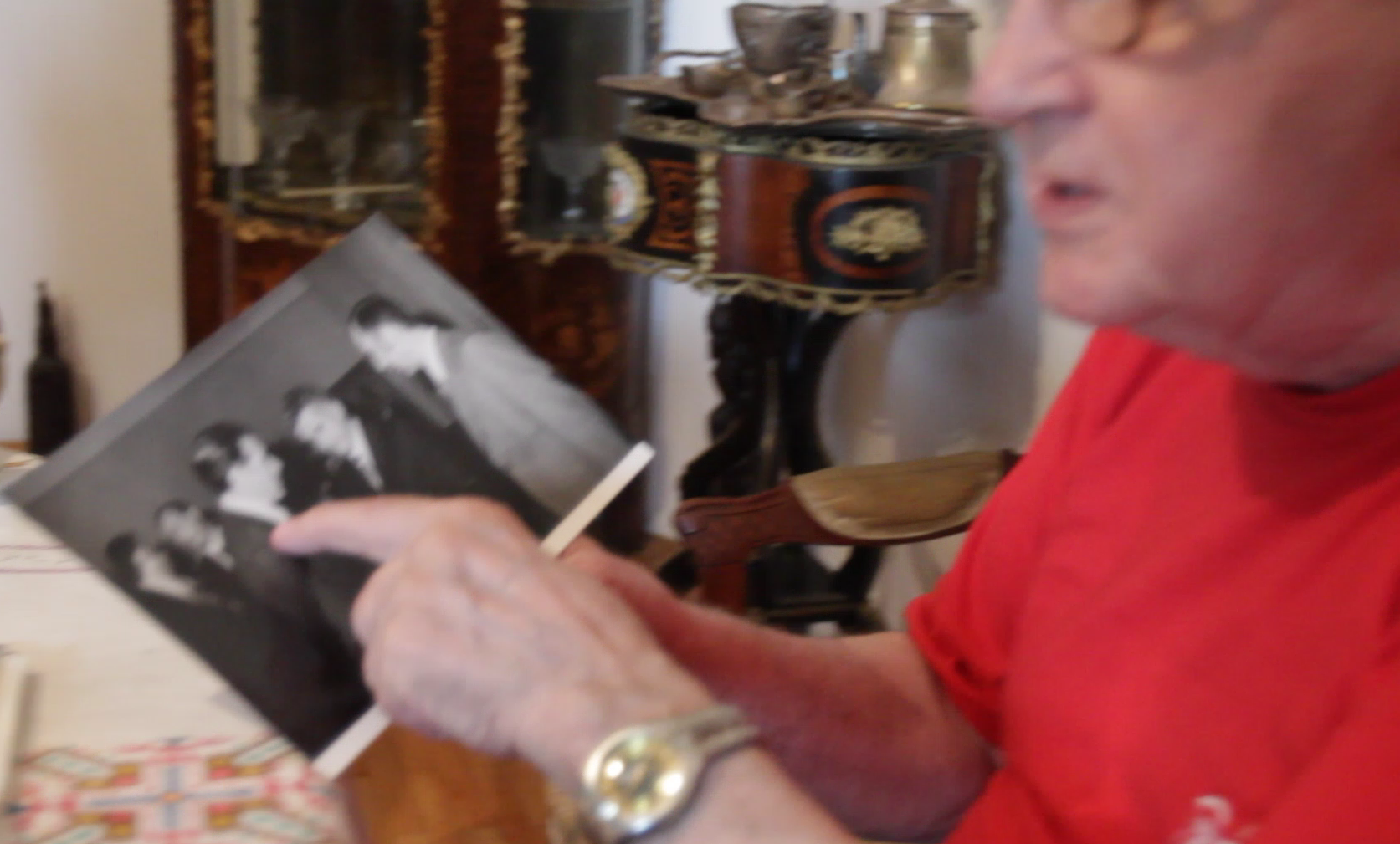 Vasile Anghel se uita pe una dintre fotografiile in care apare alaturi de Nicolae Ceusescu