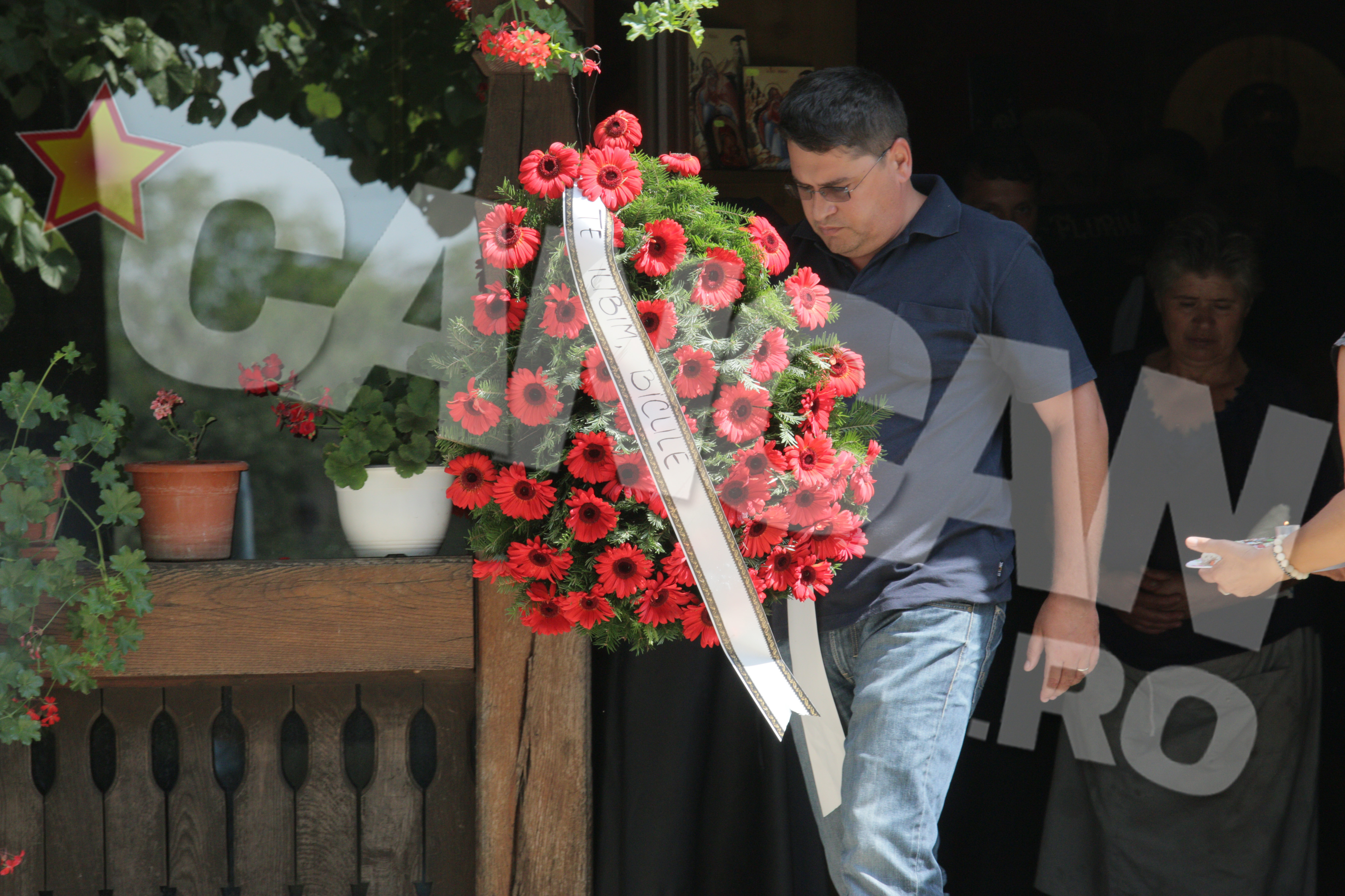 Prietenii i-au adus zeci de coroane de flori. Printre ele s-a strecurat si o jerba cu un mesaj emotionant, de la nepoti “Te iubim, Bicule!”