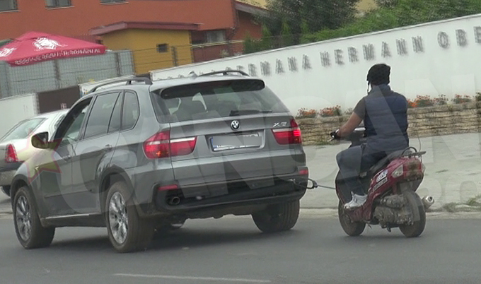Trecatorii au fost surprinsi sa vada BMW-ul cum tracta un scuter