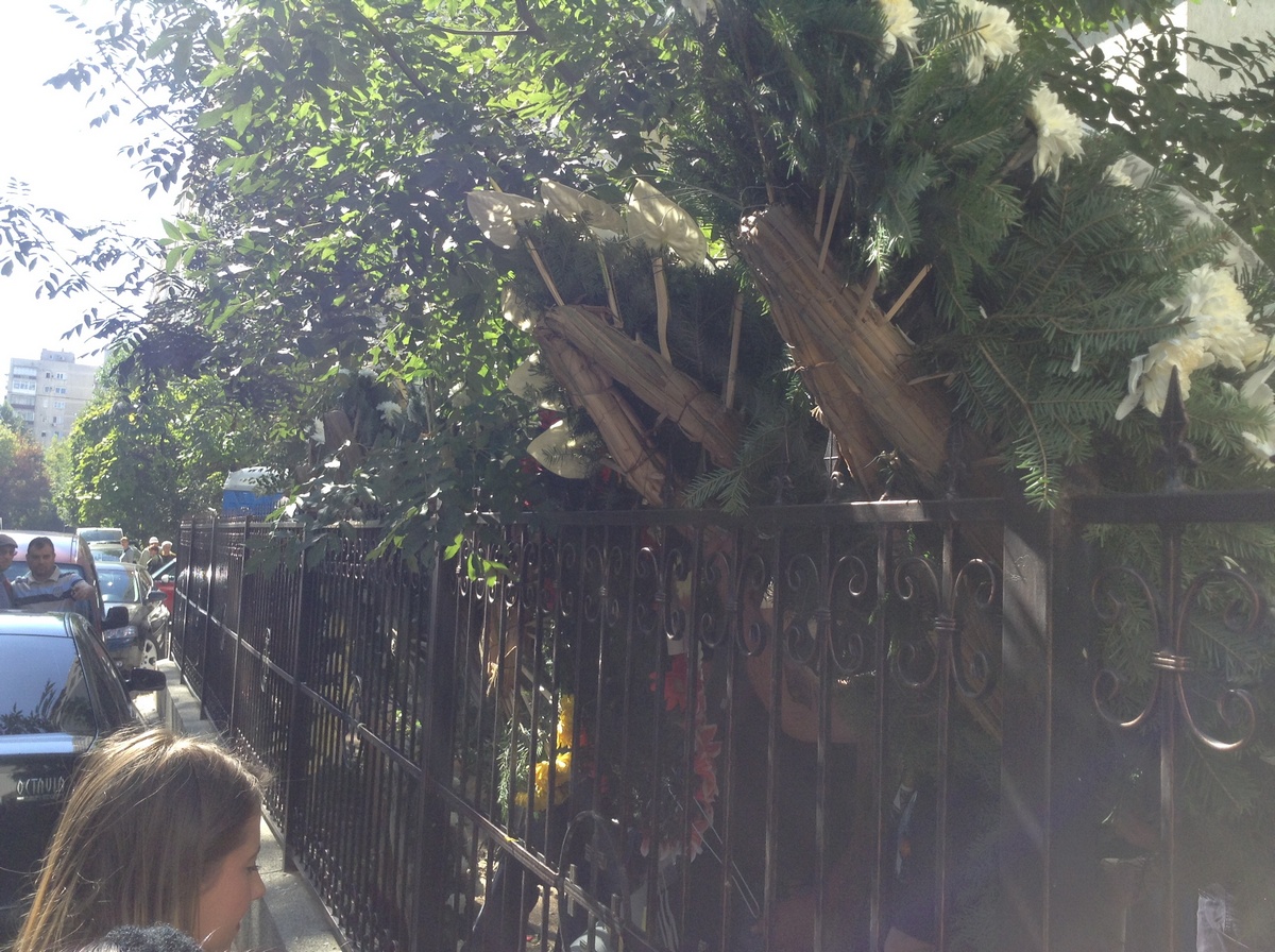 Apropiatii soferului sinucigas au umplut gardul bisericii de coroane pentru ca presa sa nu vada ce se intampla in interior