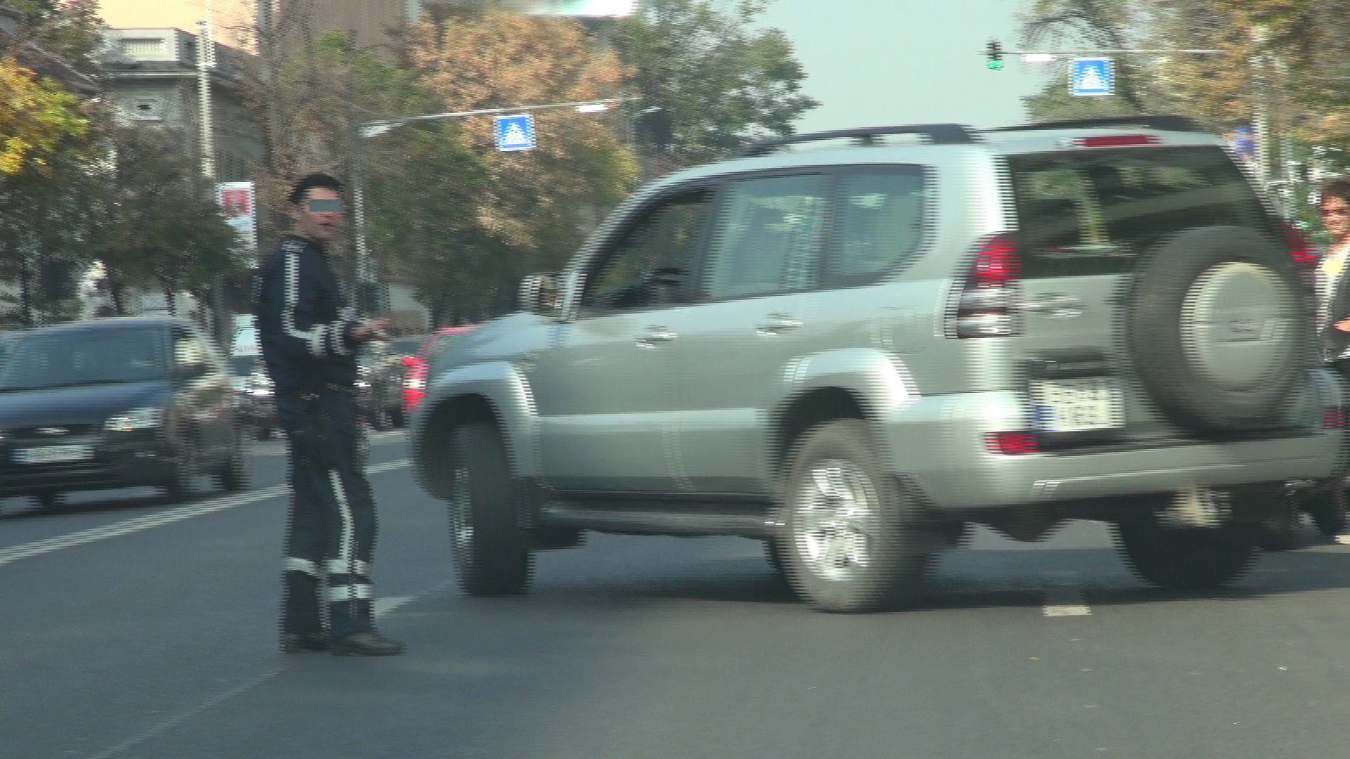 Un politist opreste masinile pentru a-i face loc sa iasa din parcare