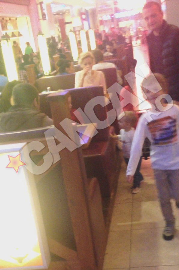 Antrenorul vorbeste cu sotia sa, care astepta comanda la un restaurant din mall