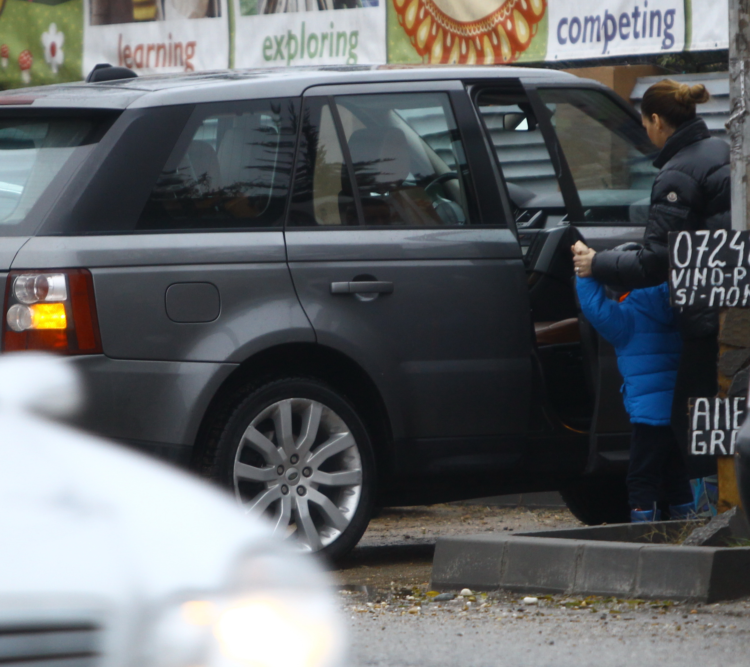 Femeia il urca pe cel mic pe scaunul din dreapta soferului