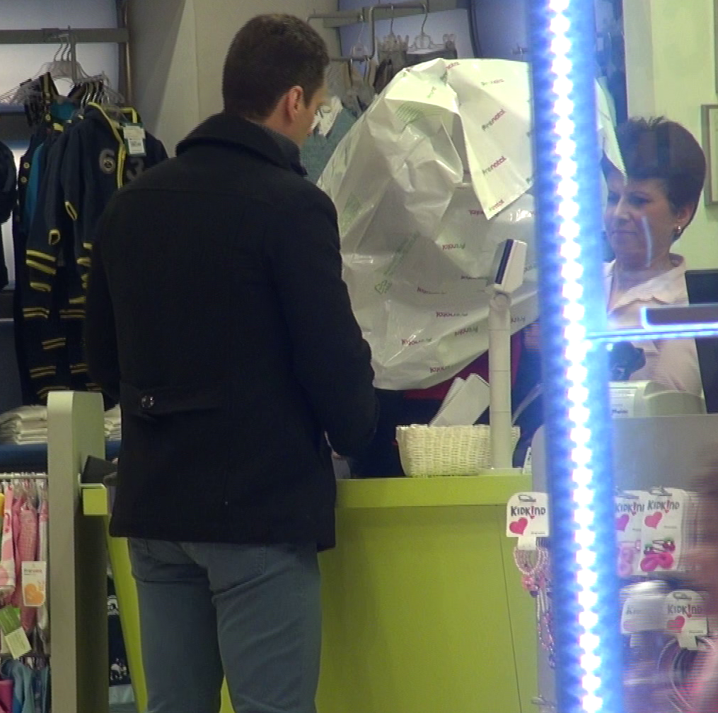 Mircea Badea asteapta ca scaunul sa fie impachetat de una dintre angajatele magazinului