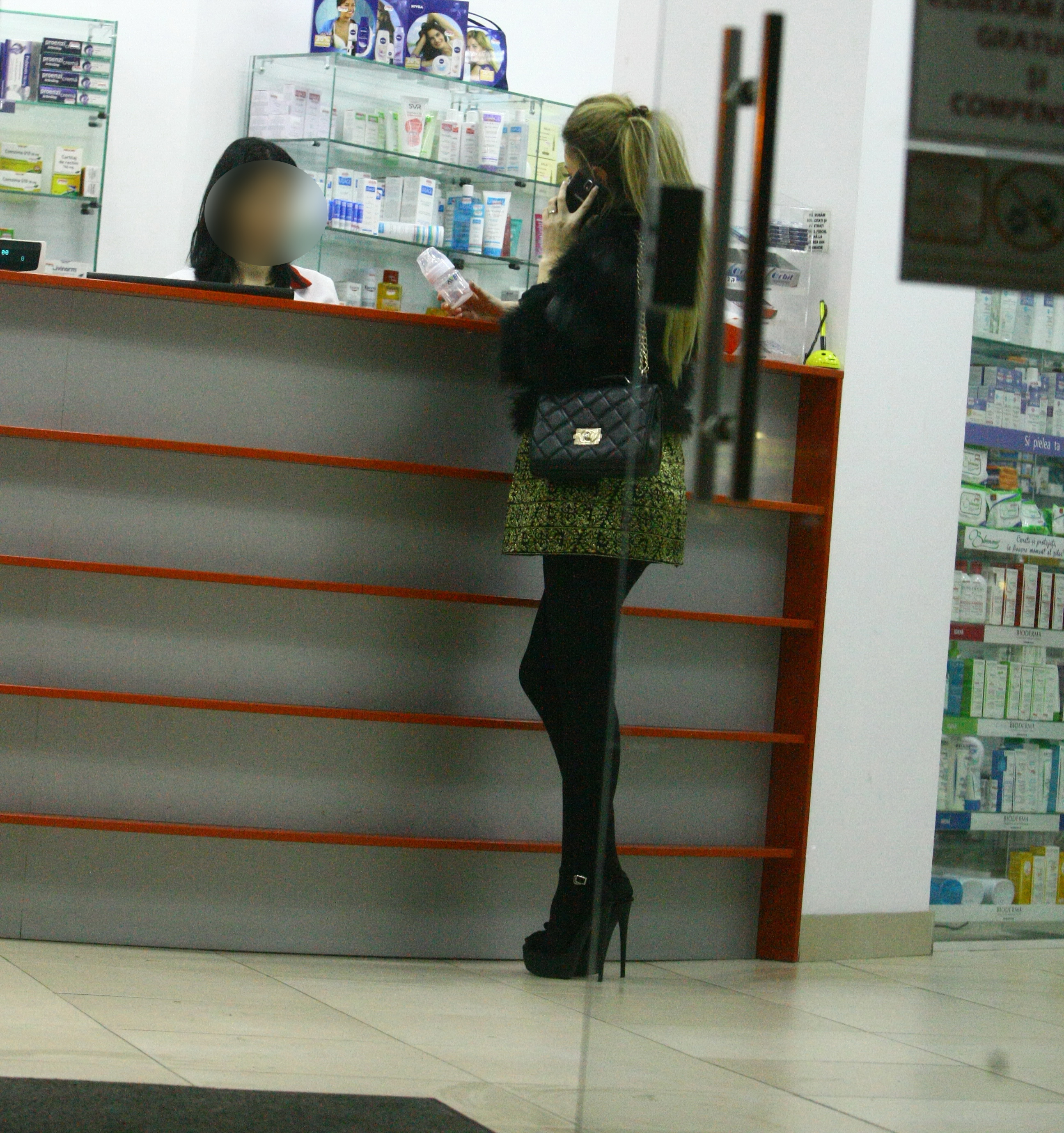 Prezentatoarea TV cumpara biberoane si vorbeste la telefon