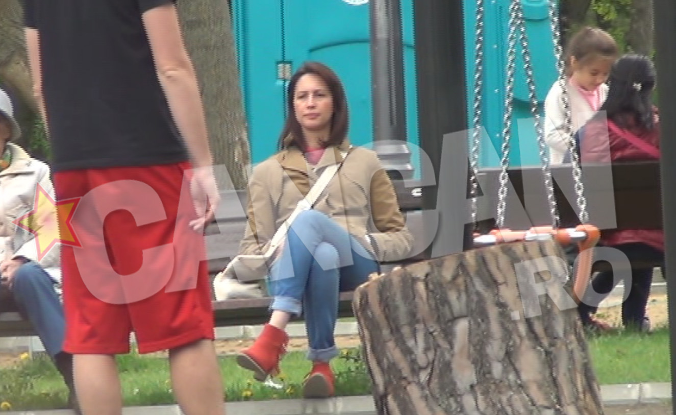 Mihaela sta pe banca, in timp ce copiii se dau in leagan