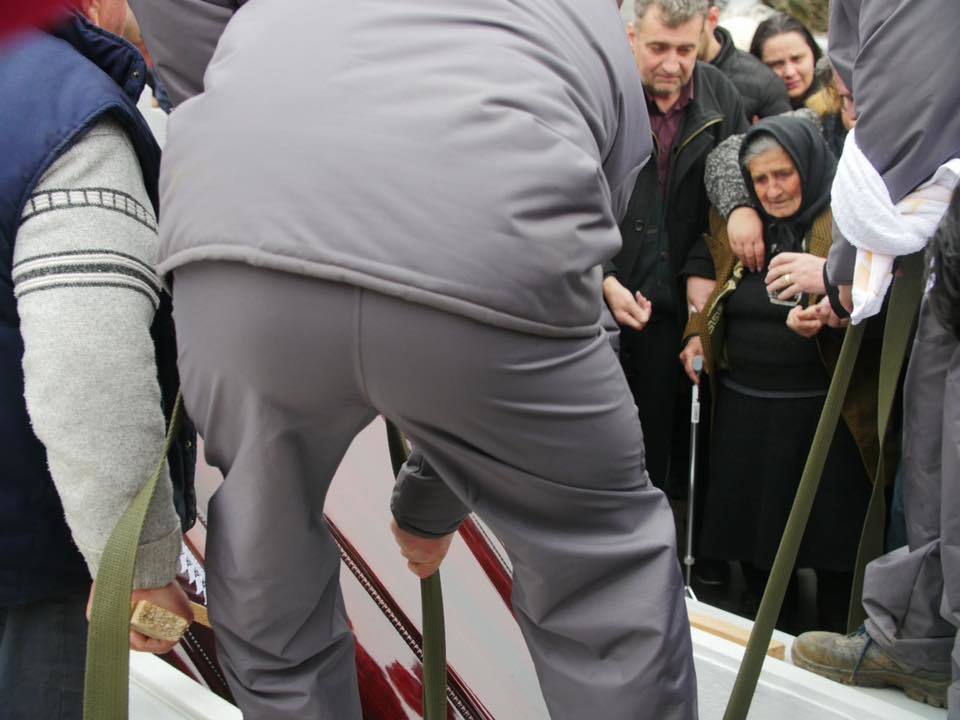 Sicriul este coborât în groapă