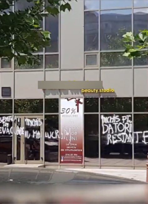 Aşa arăta salonul fotomodelei din Urlaţi după ce proprietarul spaţiului a mâzgălit toate geamurile imobilului. Niculae a făcut totul public