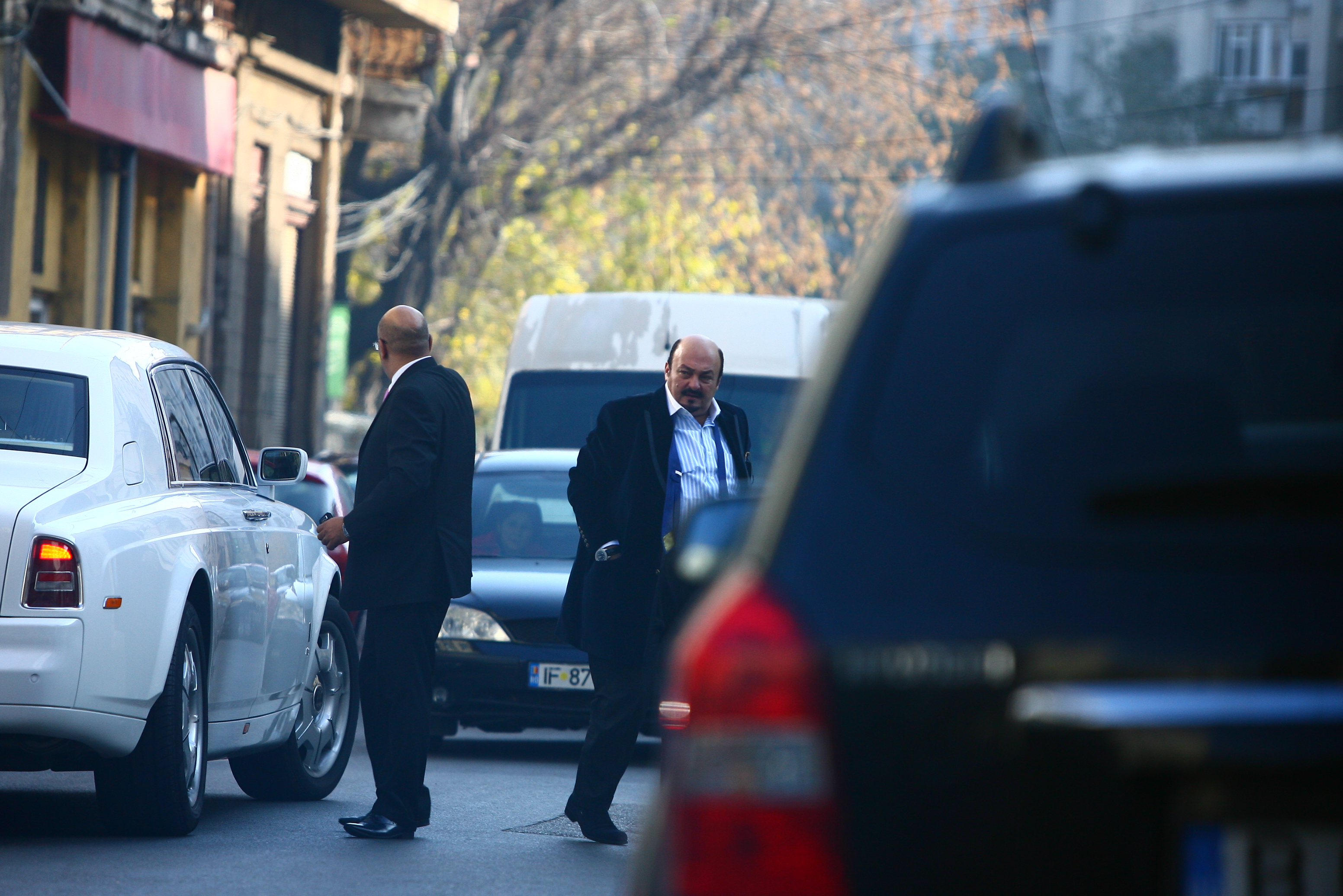 Descheiat la sacou si cravata, milionarul se pregateste pentru a intra la o croitorie de cartier