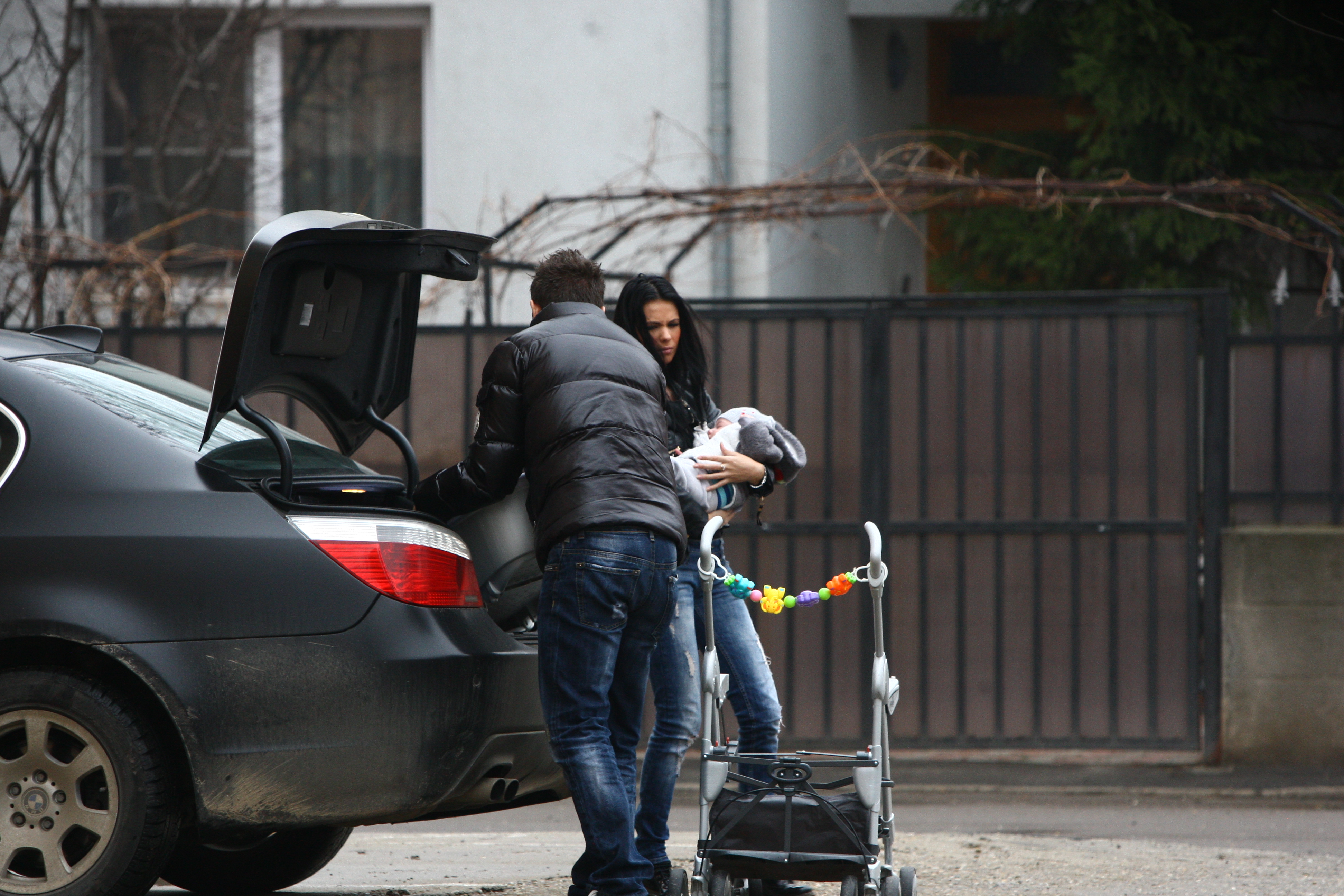 In timp ce Tibi monteaza caruciorul, Andreea tine strans copilul in brate