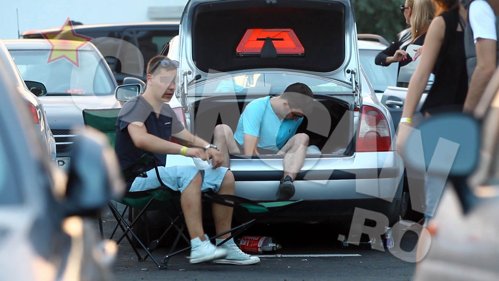 In timp ce amicul vegheaza, unul dintre pusti mestereste ceva in portbagaj