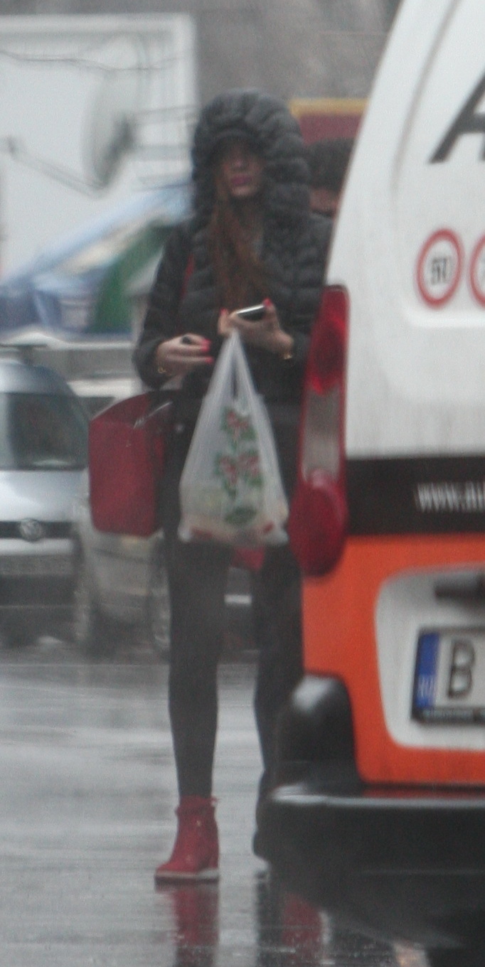 Tânăra şi-a asortat geanta de culoare roşu aprins cu ghetuţele sport, lacul de unghii şi rujul