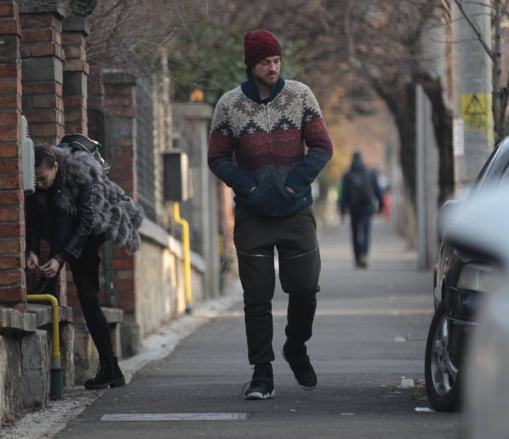 Gadola Jr., adâncit în gânduri, în timp ce soția lui s-a oprit să își lege șireturile