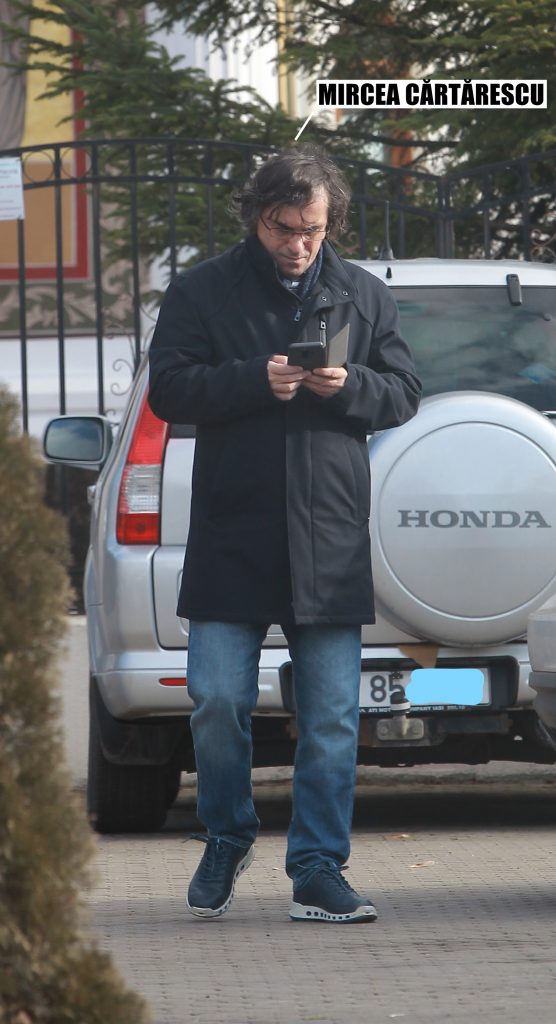 Scriitorul butonează telefonul în așteptarea fiului