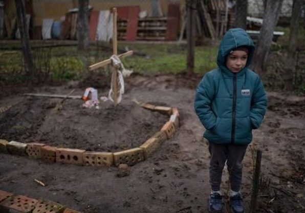 Imagine Stire Marina a murit sub privirile copiilor săi, după ce rușii au bombardat Bucha. Imaginile cu Vlad, băiețelul ei, care aduce conserve cu mâncare la mormântul mamei sale au făcut înconjurul lumii | 2review.ro