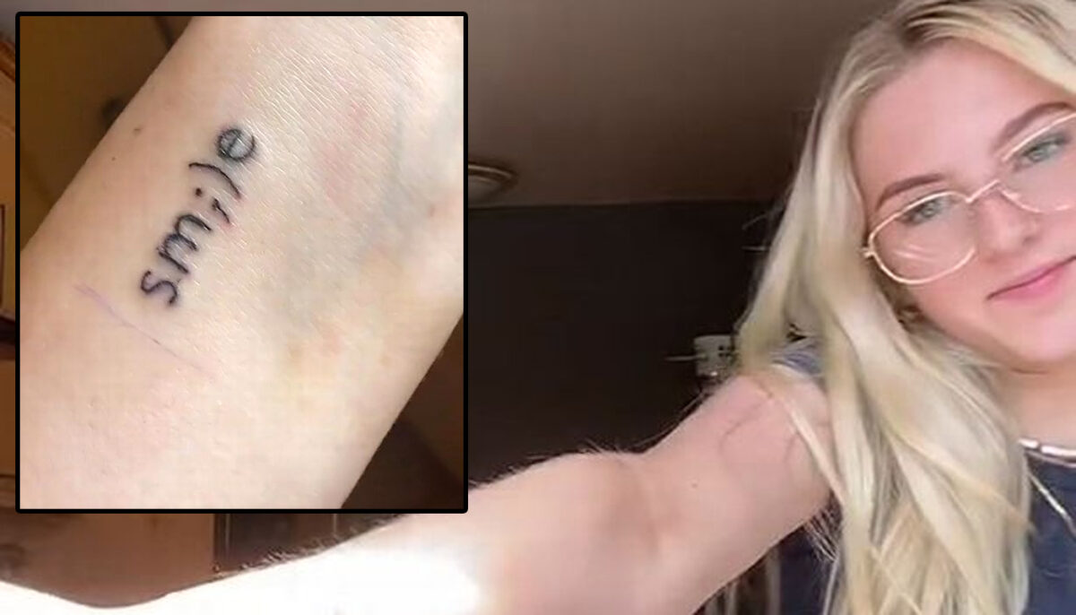 Tânăra din imagine și-a tatuat cuvântul „smile” pe antebrațul drept, dar acum regretă profund. Ce cuvânt murdar apare în reflexia oglinzii