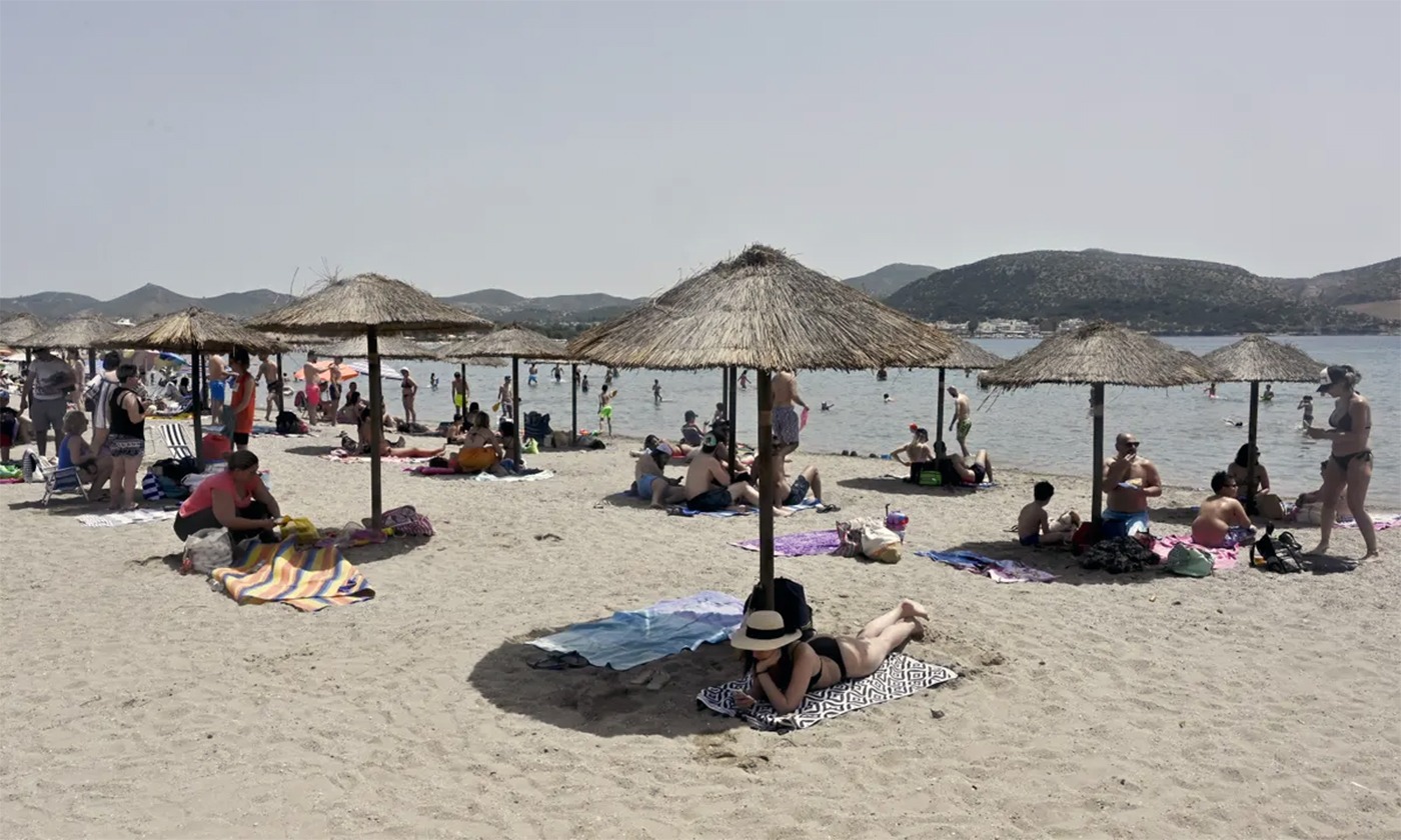 Turiști la plajă în Grecia