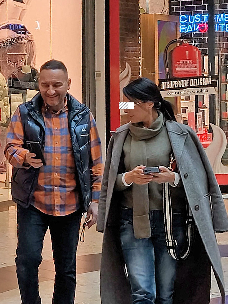 Cei doi se uită în telefonul afaceristului