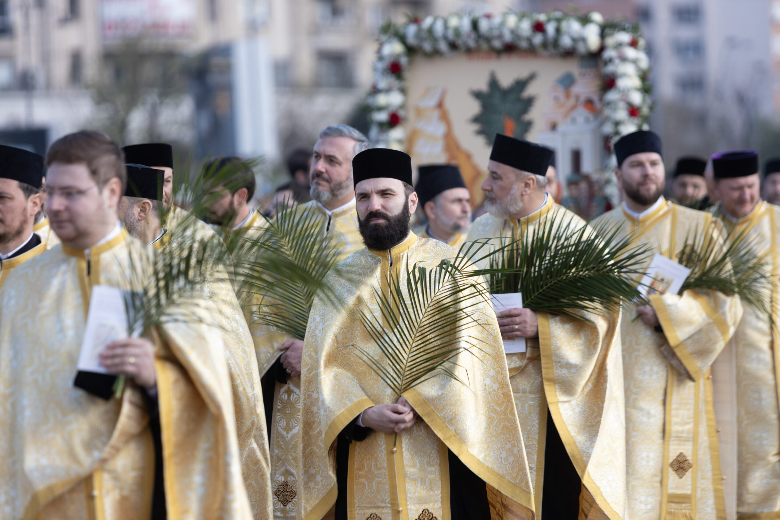 preoti ortodocsi care tin frunze in mana la procesiunea de florii